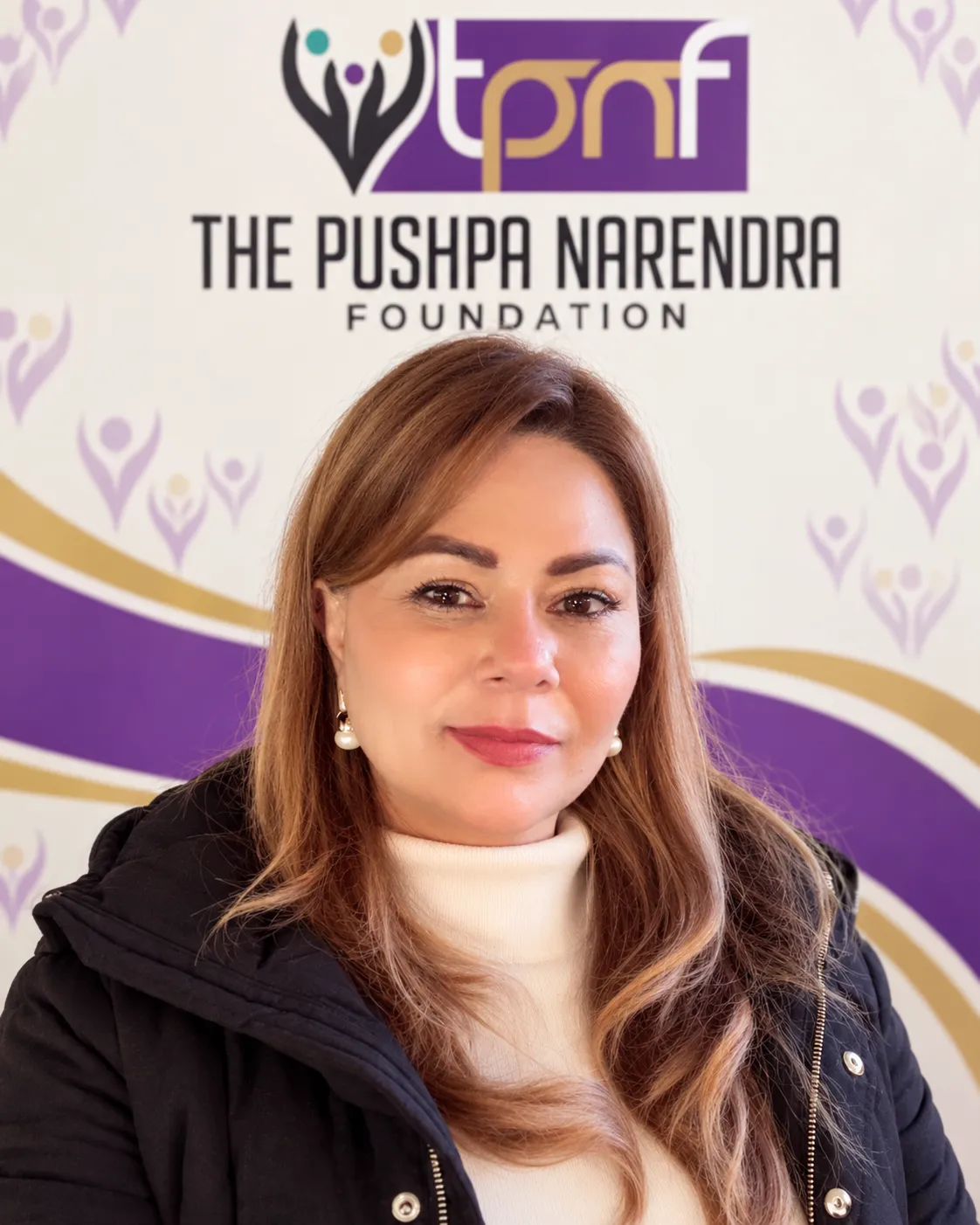 Gurpreet Dogra, in front of a branded TPNF backdrop.