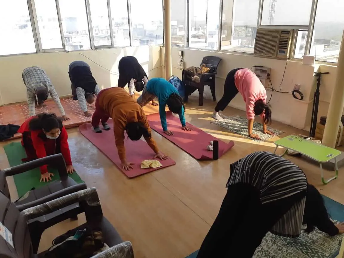 Participants folding forward into downward dog on their mats.