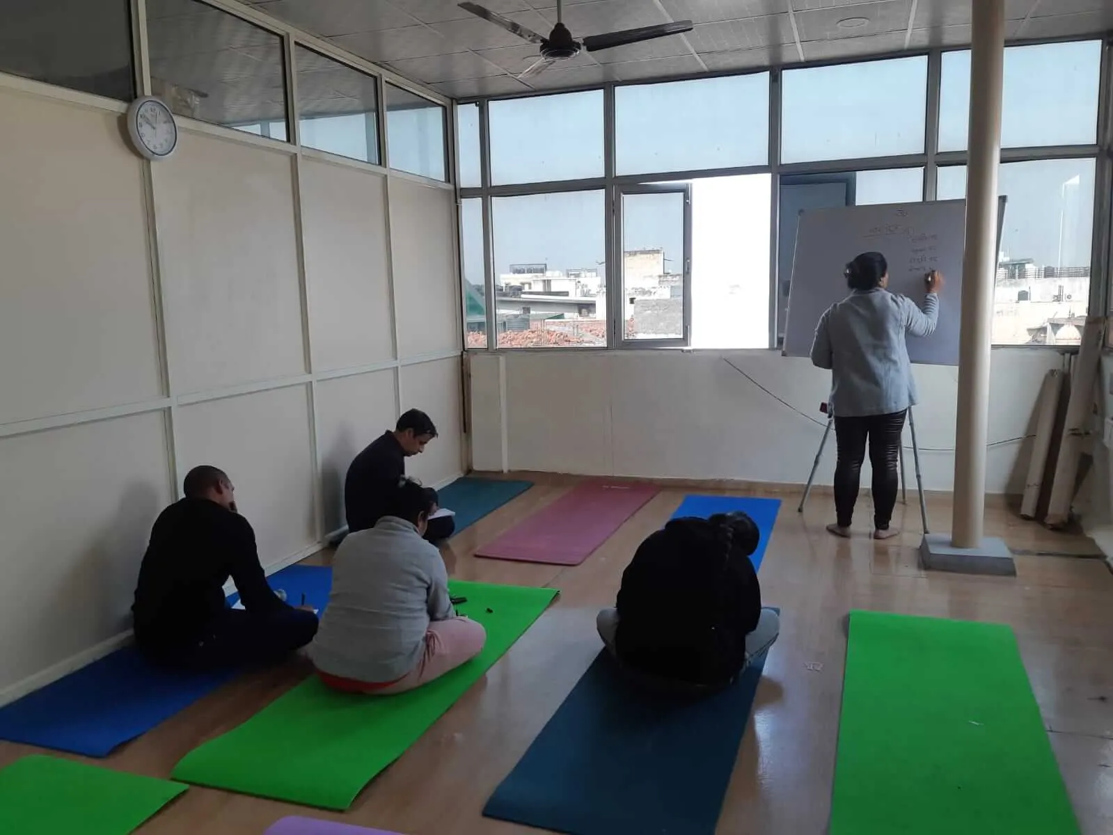 Participants seated on mats listening to a TPNF instructor.